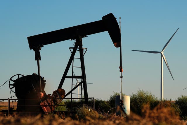 <p>Oil pumpjacks operate in the foreground as the Buckeye Wind Energy wind farm rises in the distance last year near Hays, Kansas</p>