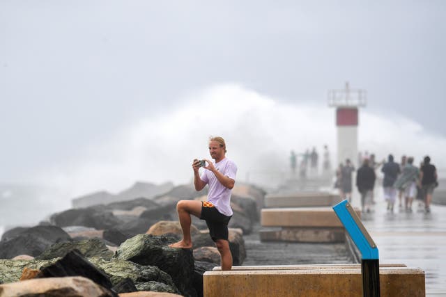 <p>People observe the weather in the Seaway on the Gold Coast of Australia ahead of the arrival of Cyclone Alfred</p>